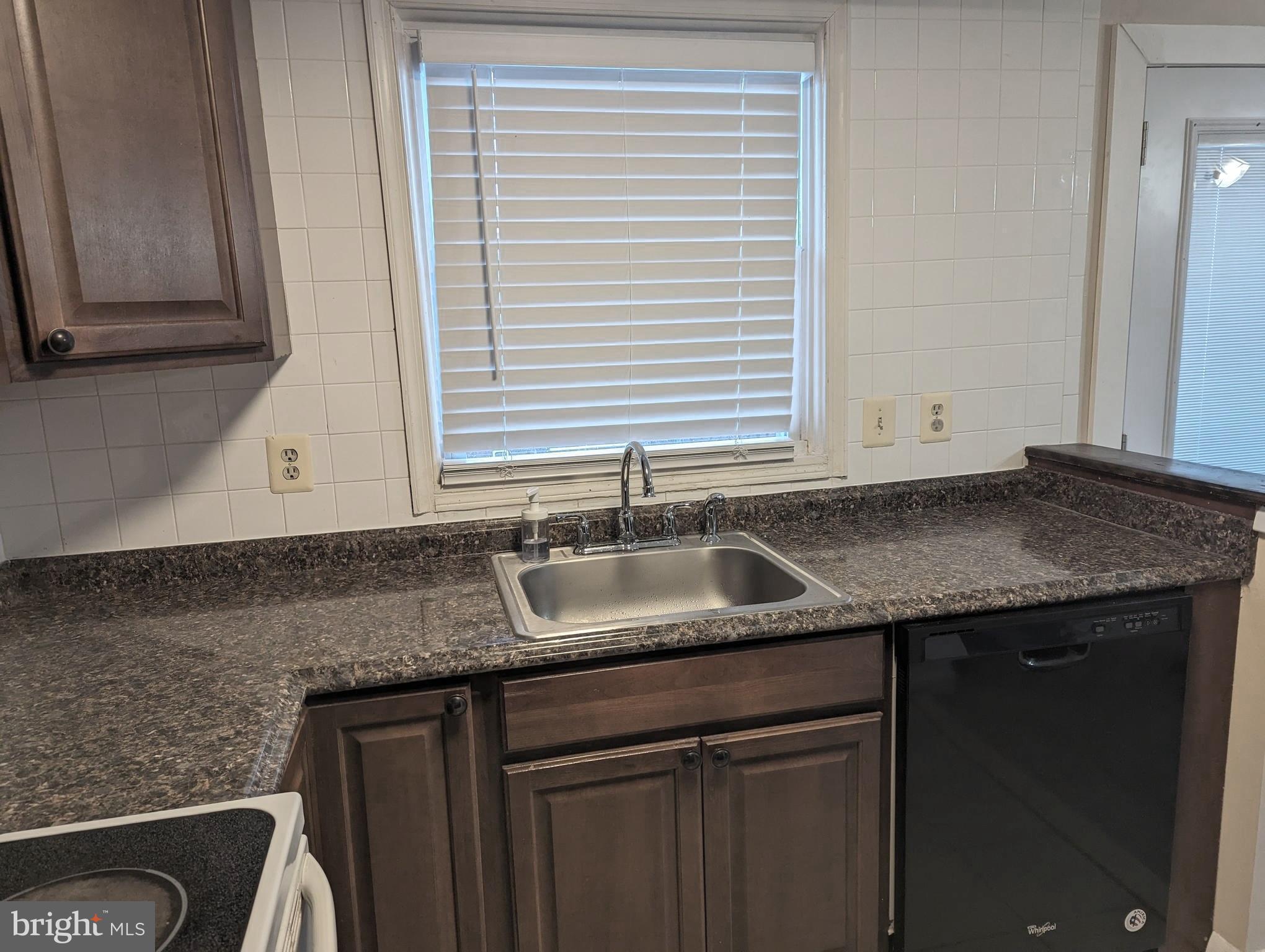 9119 Aspenpark Court Lorton, VA 22079 - Photo 19 of 32 a kitchen with granite countertop cabinets sink and window