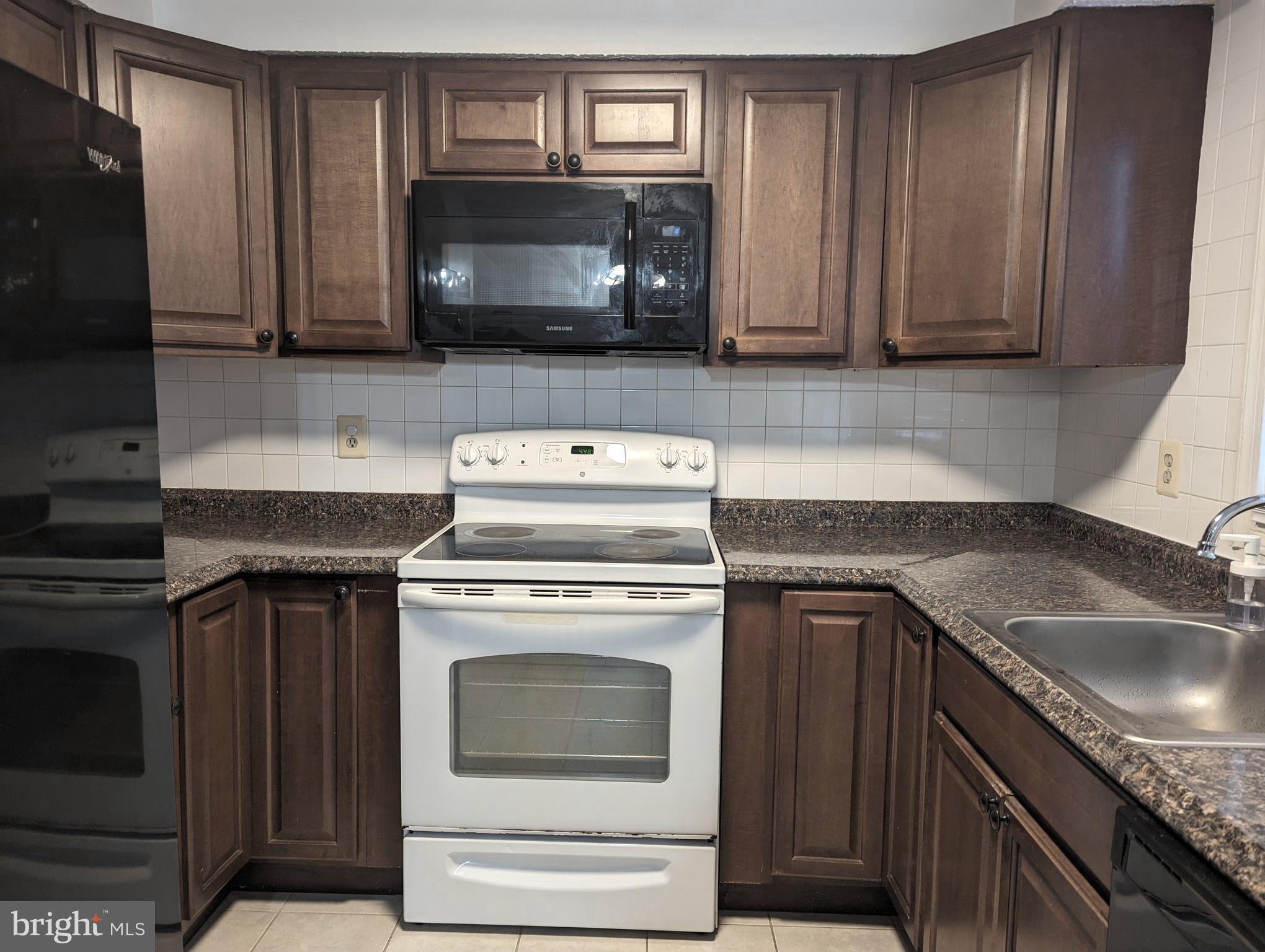 9119 Aspenpark Court Lorton, VA 22079 - Photo 3 of 32 a kitchen with granite countertop a stove microwave and sink