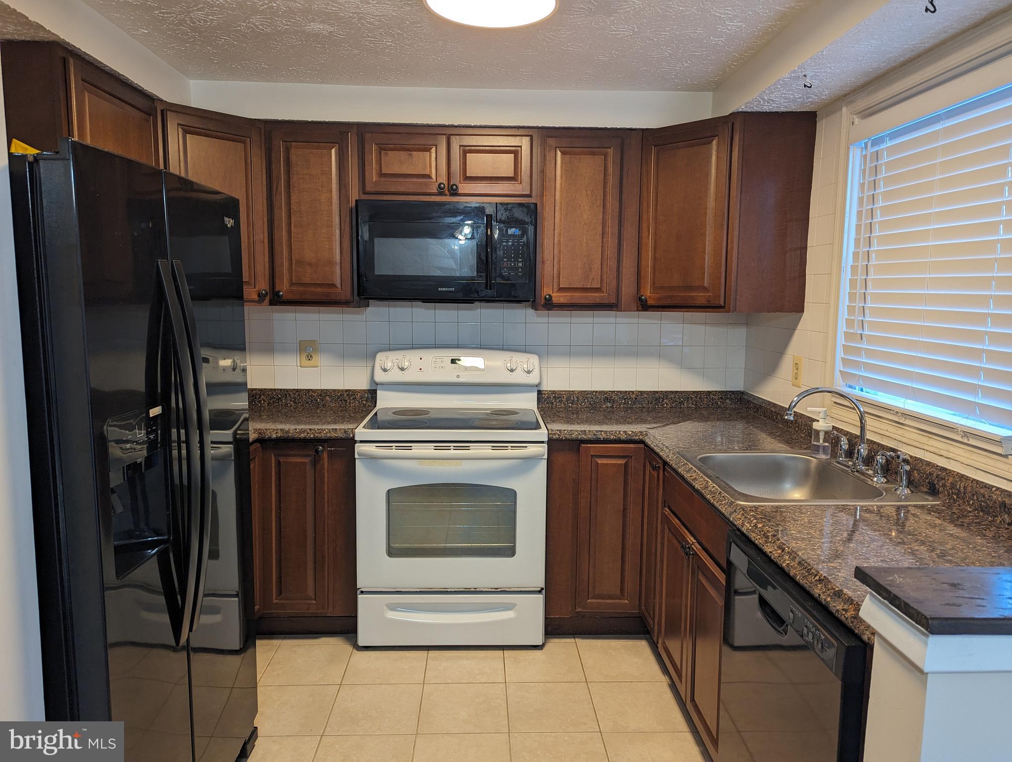 9119 Aspenpark Court Lorton, VA 22079 - Photo 6 of 32 a kitchen with a sink stove and refrigerator