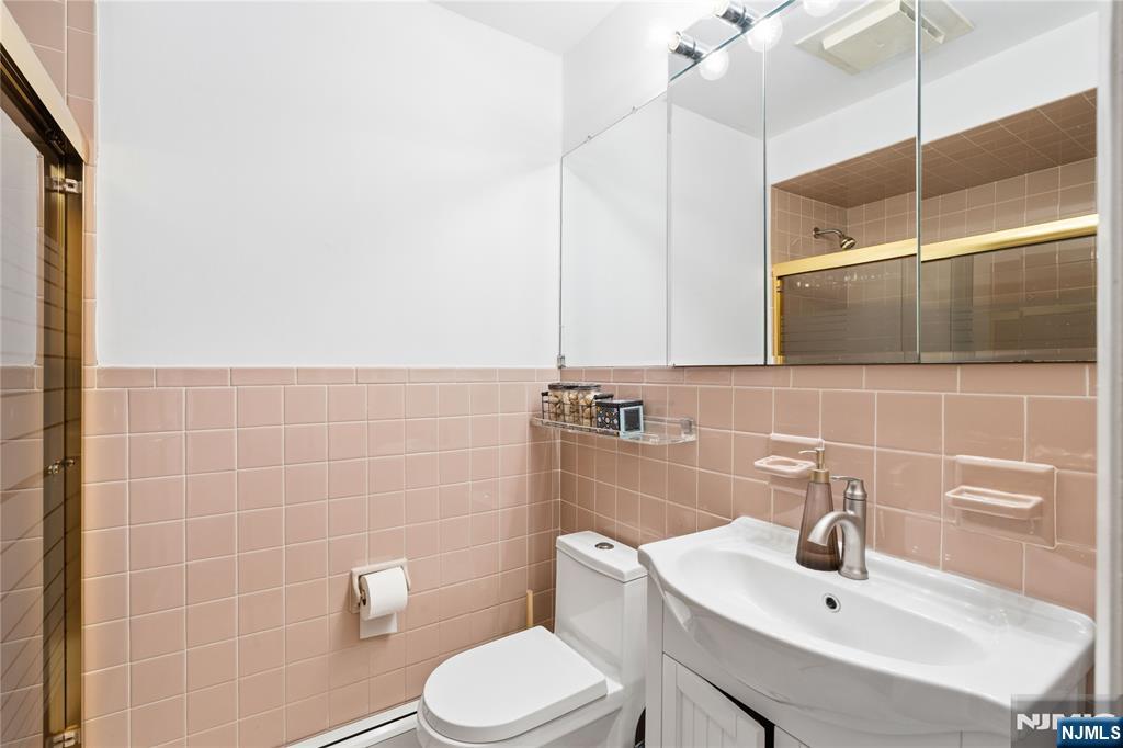 1675 Broad Street Bloomfield, NJ 07003 - Photo 17 of 35 a bathroom with a sink a toilet and mirror