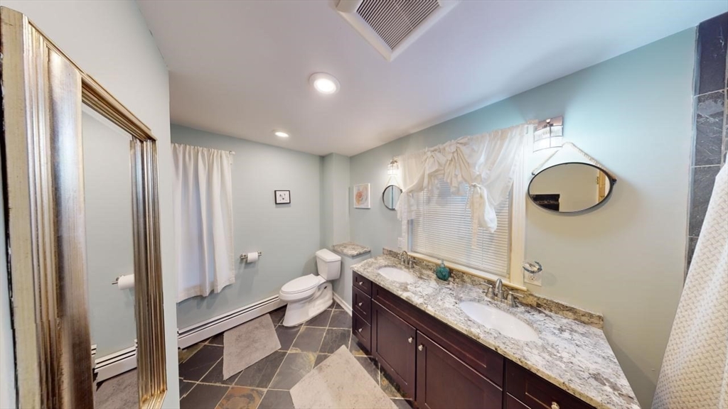 57 Green Street Marblehead, MA 01945 - Photo 20 of 29 a spacious bathroom with a granite countertop sink mirror vanity and toilet