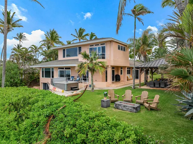 a front view of a house with garden and sitting area