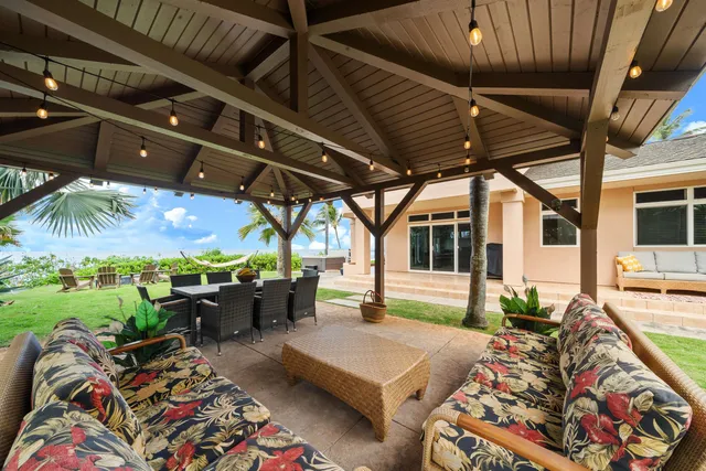 a view of a patio with table and chairs under an umbrella with a small yard
