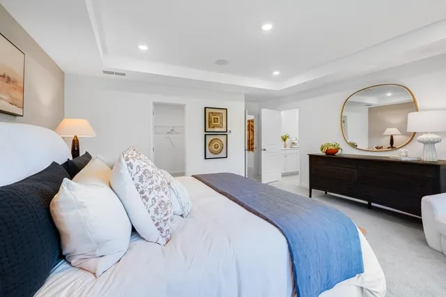 a bedroom with a bed a dresser and a painting on the wall