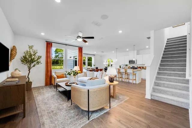 a kitchen with stainless steel appliances kitchen island granite countertop a dining table chairs and white cabinets