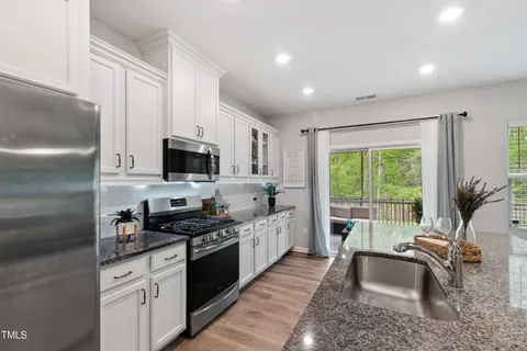 a kitchen with granite countertop a sink stainless steel appliances and cabinets