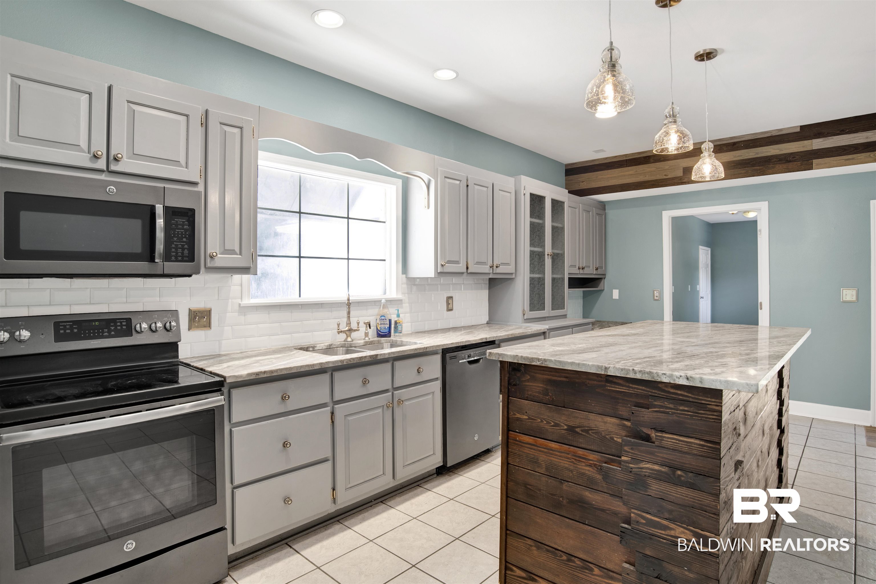 11835 Island Drive Foley, AL 36535 - Photo 26 of 53 Kitchen featuring appliances with stainless steel finishes, light tile patterned floors, a center island, glass insert cabinets, and recessed lighting