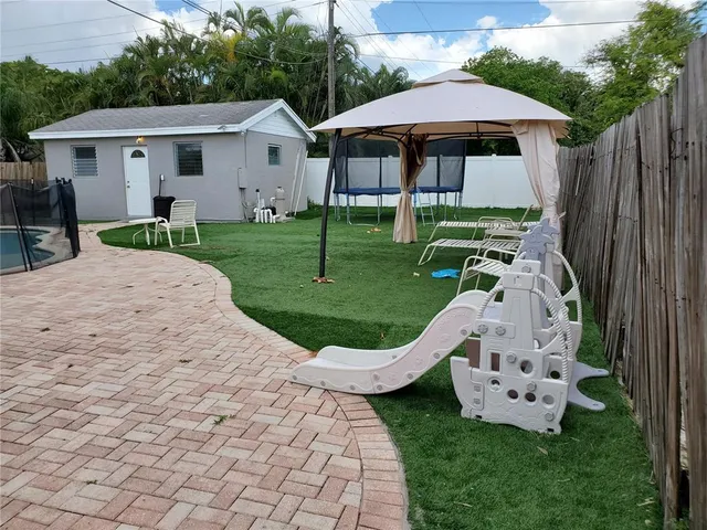 a view of a house with backyard sitting area and garden