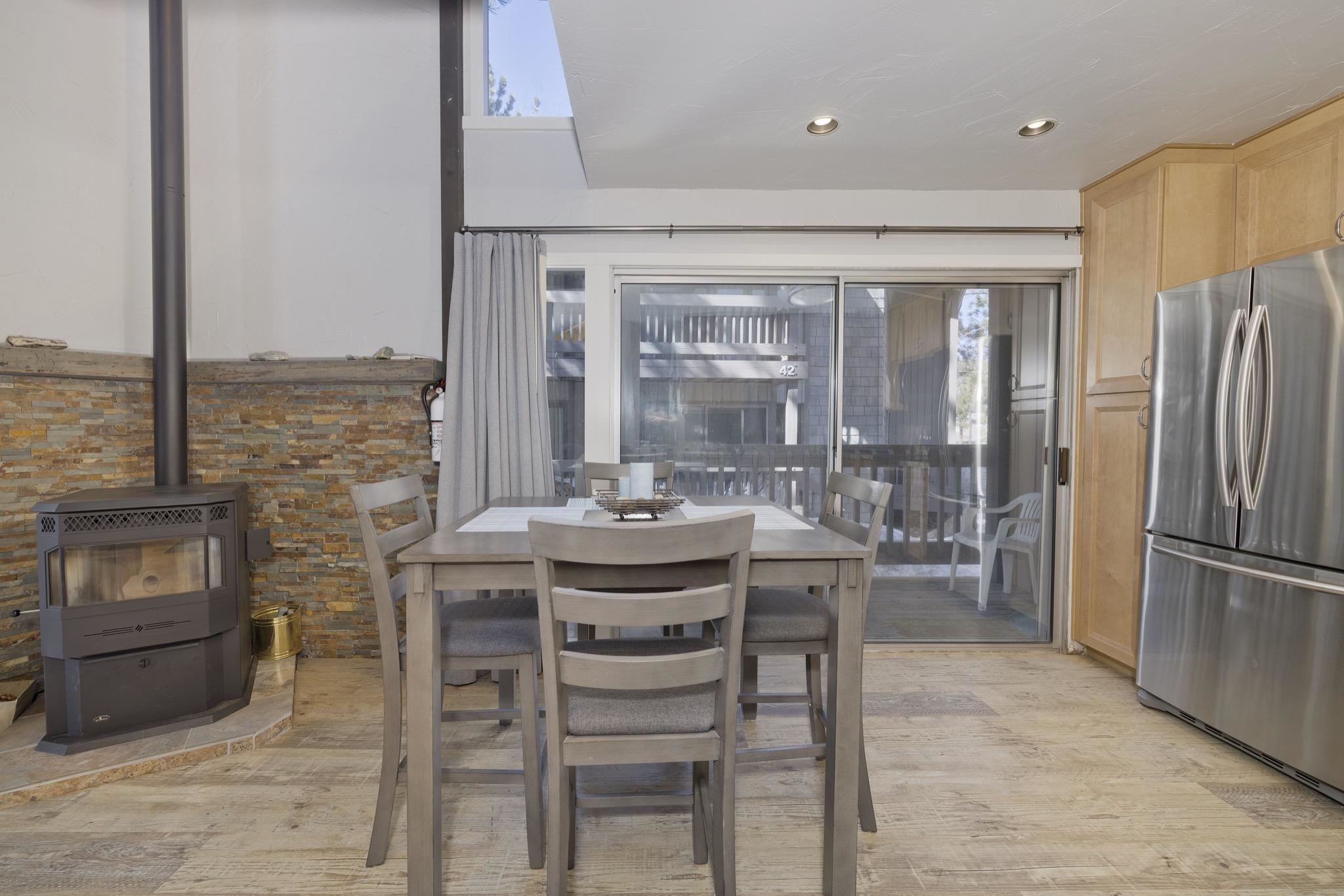 286 Old Mammoth Road, Unit 37 Mammoth Lakes, CA 93546 - Photo 13 of 33 Dining area featuring light wood-style flooring, a wood stove, and recessed lighting