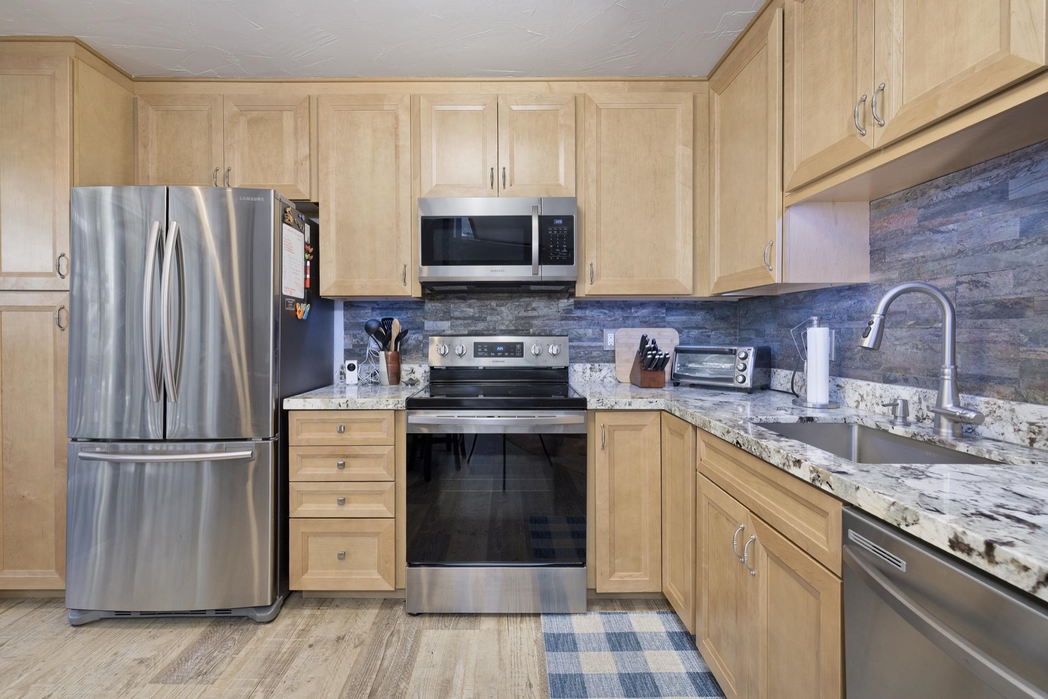 286 Old Mammoth Road, Unit 37 Mammoth Lakes, CA 93546 - Photo 14 of 33 Kitchen with light wood finish cabinets, stainless steel appliances, light stone countertops, and light wood-type flooring