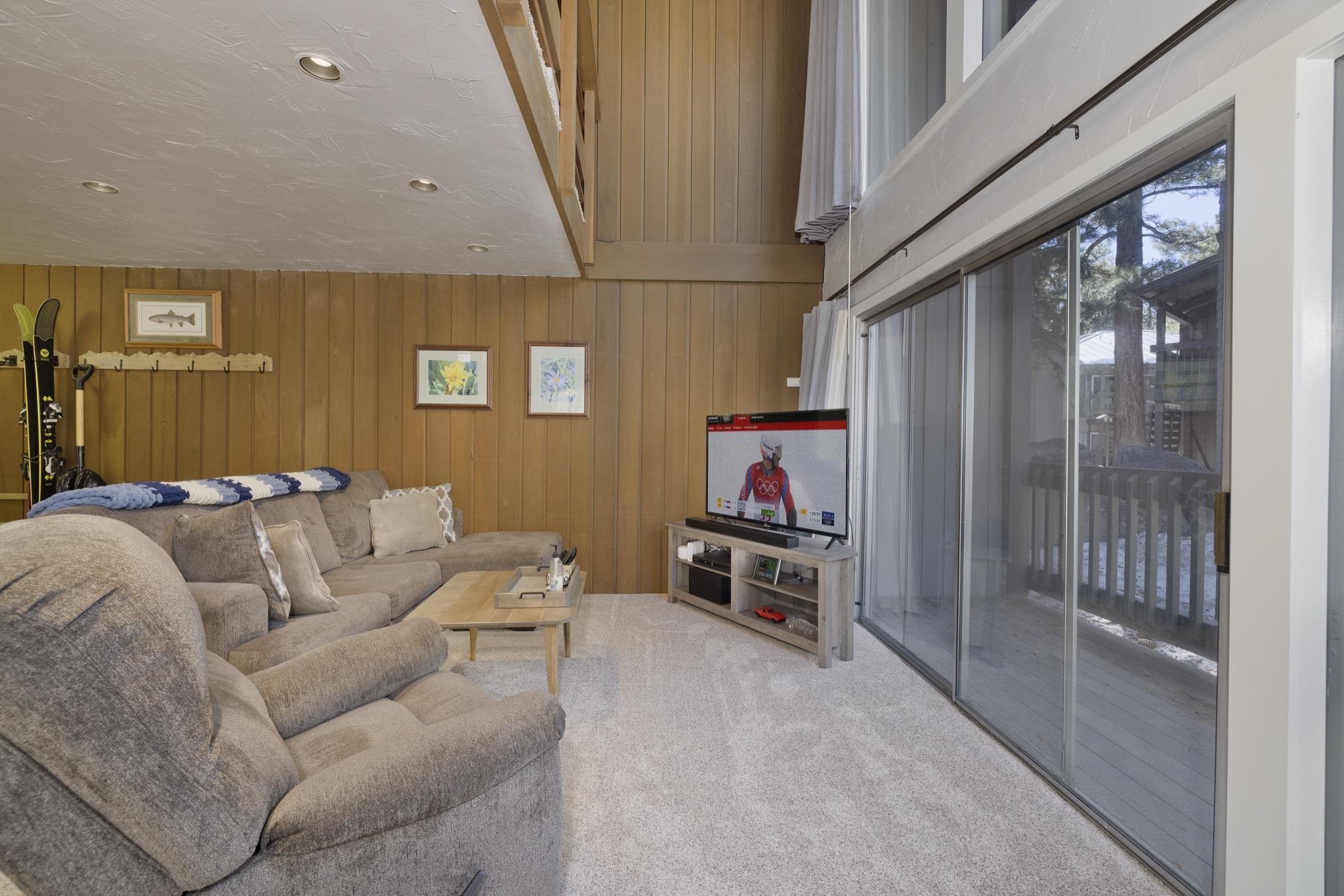 286 Old Mammoth Road, Unit 37 Mammoth Lakes, CA 93546 - Photo 8 of 33 Living area with wood walls and light colored carpet
