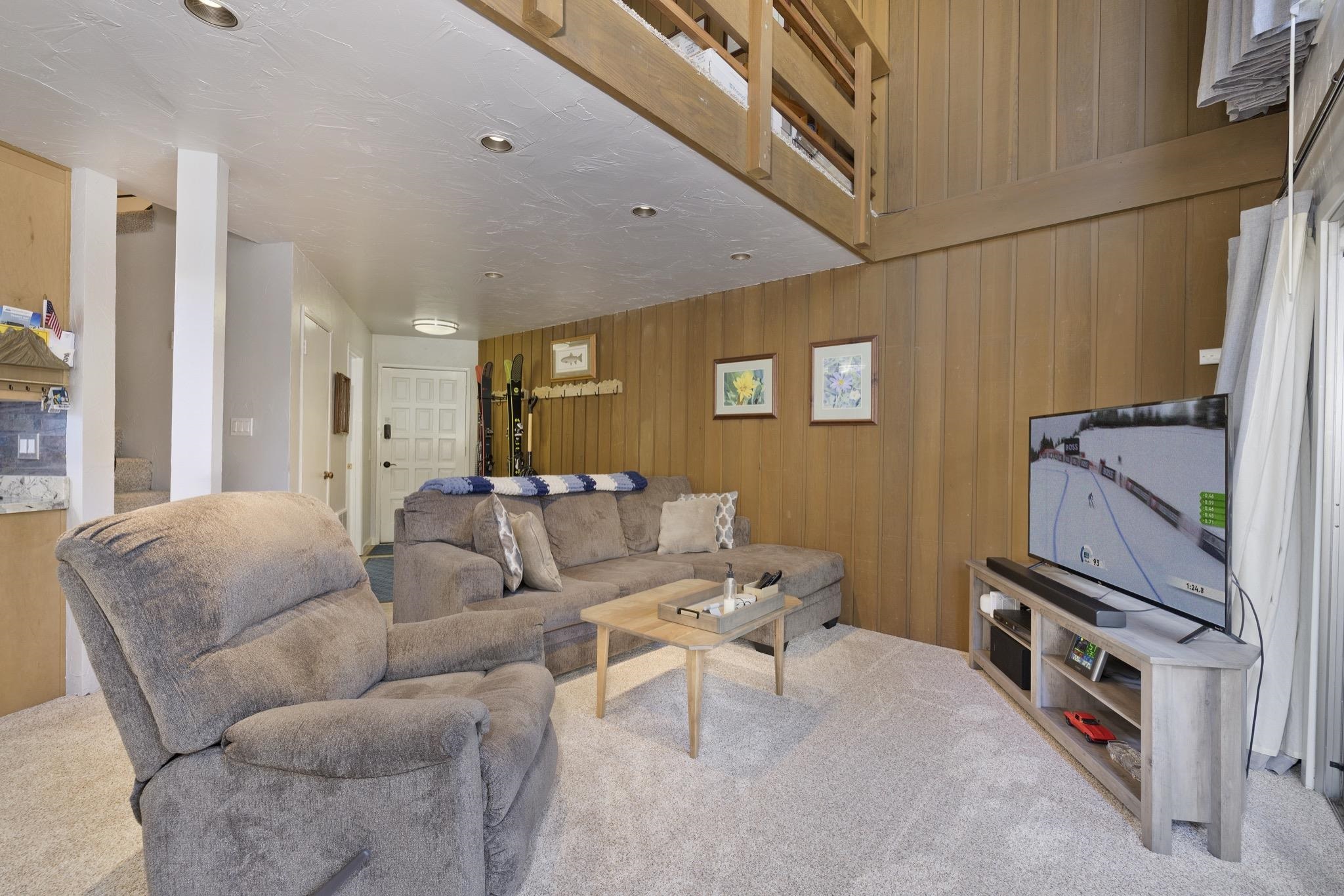 286 Old Mammoth Road, Unit 37 Mammoth Lakes, CA 93546 - Photo 9 of 33 Living room with wooden walls and light carpet