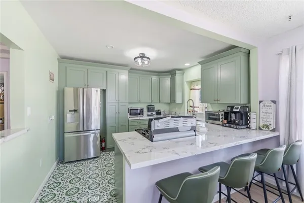 a kitchen with stainless steel appliances granite countertop a refrigerator and a sink