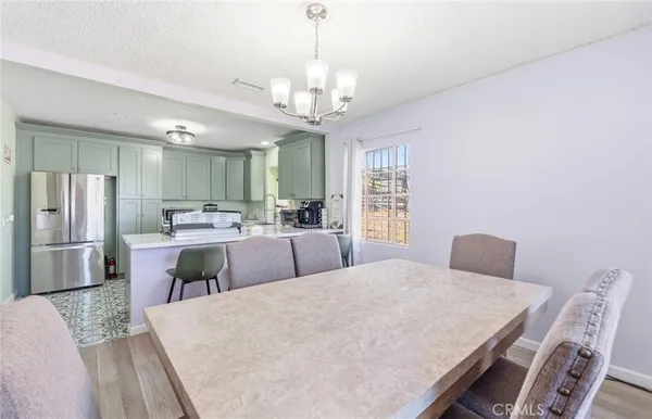 a large kitchen with a table chairs stainless steel appliances and cabinets