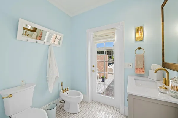 a bathroom with a granite countertop toilet a sink a mirror and a window