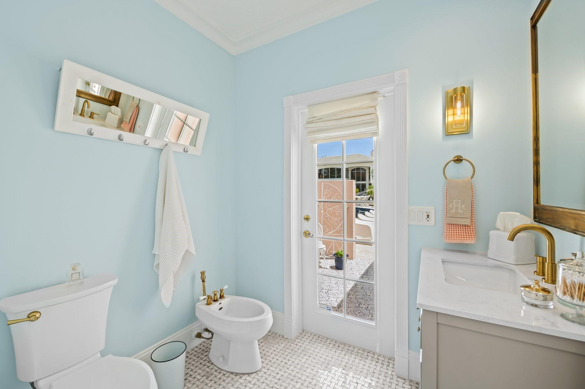 2342 Northeast 26th Street Lighthouse Point, FL 33064 - Photo 15 of 33 a bathroom with a toilet sink and mirror