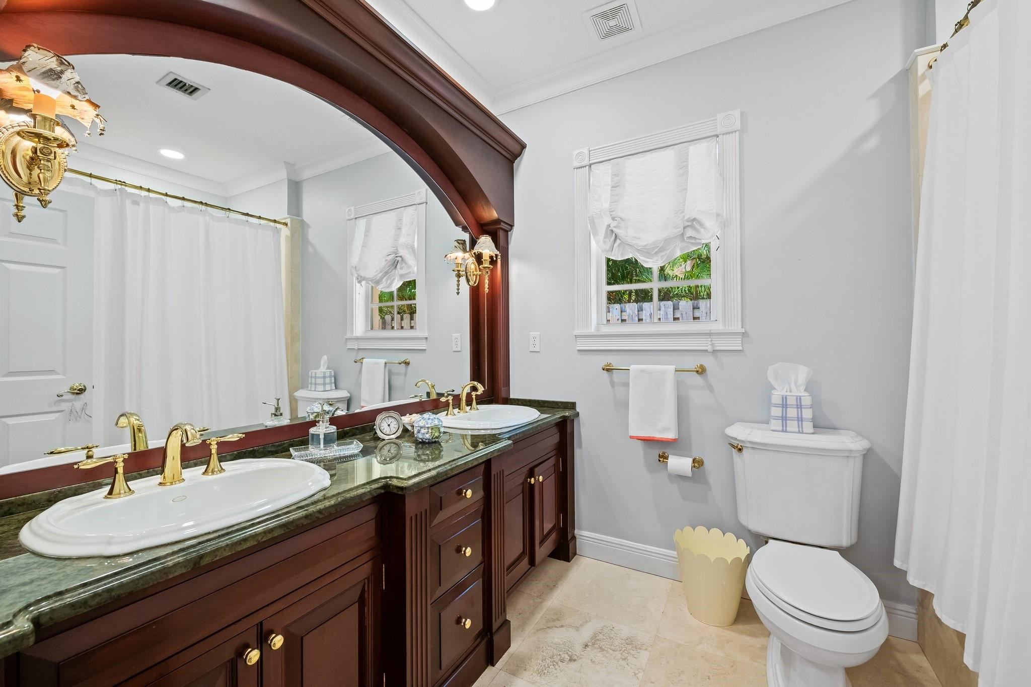 2342 Northeast 26th Street Lighthouse Point, FL 33064 - Photo 26 of 45 a bathroom with a granite countertop toilet a sink a mirror and a window