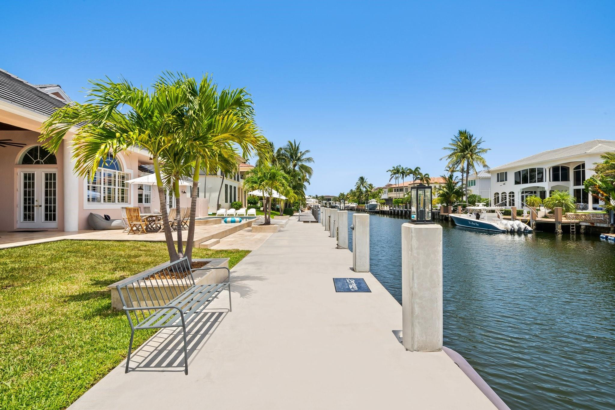 2342 Northeast 26th Street Lighthouse Point, FL 33064 - Photo 5 of 45 a view of a swimming pool with a lawn chairs under palm trees