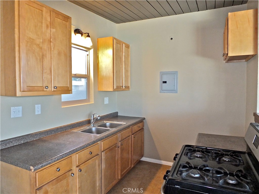 17031 7th Street, Unit A Sunset Beach, CA 90742 - Photo 13 of 27 a kitchen with sink a stove and cabinets
