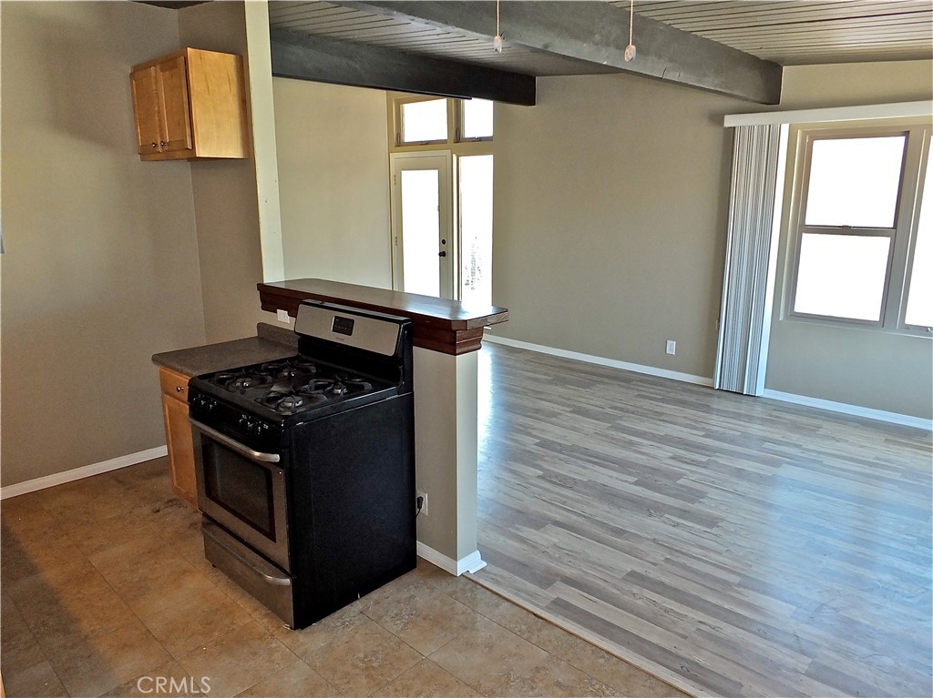 17031 7th Street, Unit A Sunset Beach, CA 90742 - Photo 15 of 27 a kitchen with a stove and wooden floor