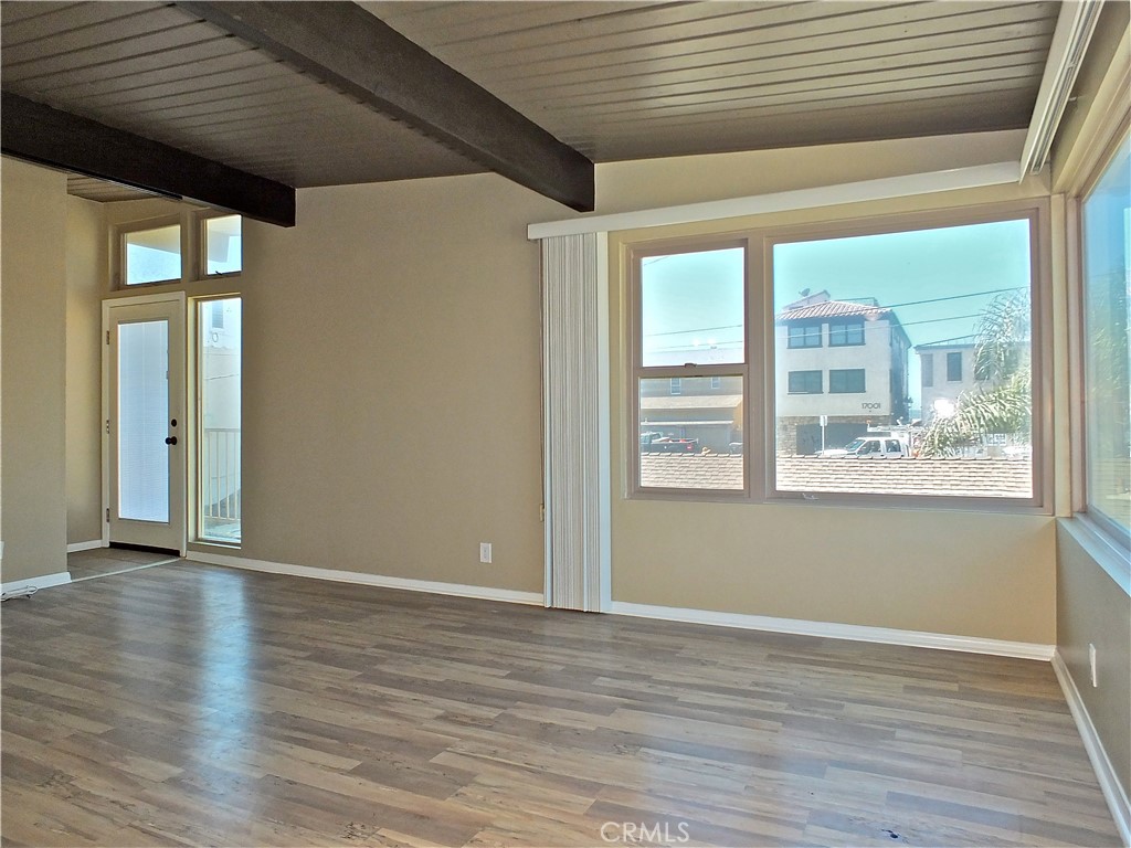 17031 7th Street, Unit A Sunset Beach, CA 90742 - Photo 8 of 27 a view of an empty room with wooden floor and a window