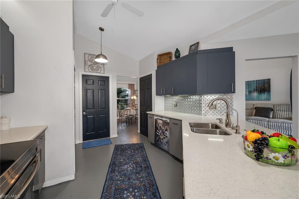 220 37th Avenue Northeast Naples, FL 34120 - Photo 13 of 49 a kitchen with stainless steel appliances kitchen island granite countertop a refrigerator and a stove top oven