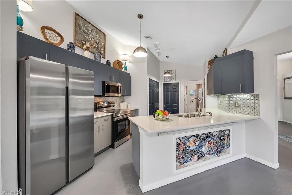 220 37th Avenue Northeast Naples, FL 34120 - Photo 14 of 49 a kitchen with stainless steel appliances granite countertop a refrigerator a stove and a sink