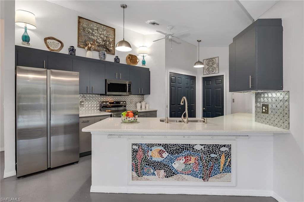 220 37th Avenue Northeast Naples, FL 34120 - Photo 15 of 49 a kitchen with stainless steel appliances granite countertop a refrigerator a sink and a stove