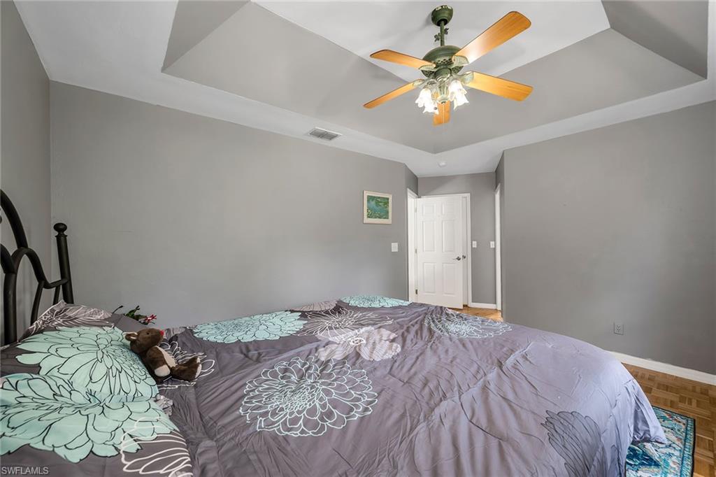 220 37th Avenue Northeast Naples, FL 34120 - Photo 24 of 49 a bedroom with a bed and a chandelier