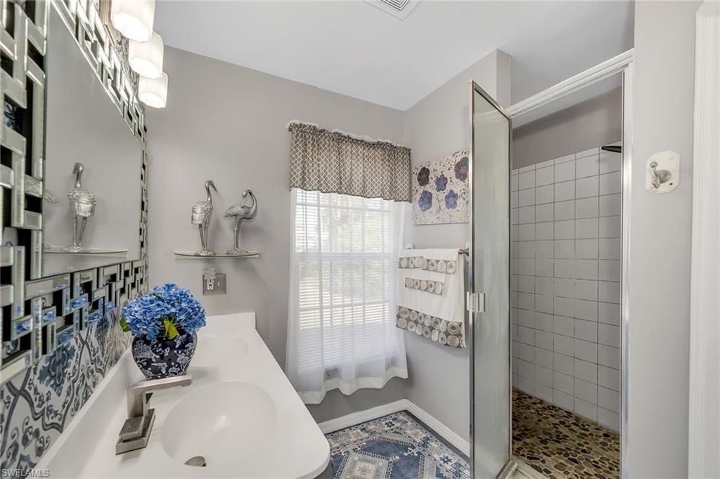 220 37th Avenue Northeast Naples, FL 34120 - Photo 25 of 49 a bathroom with a shower and a sink
