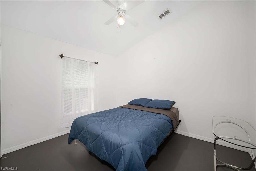 220 37th Avenue Northeast Naples, FL 34120 - Photo 28 of 49 a bedroom with a bed and a ceiling fan