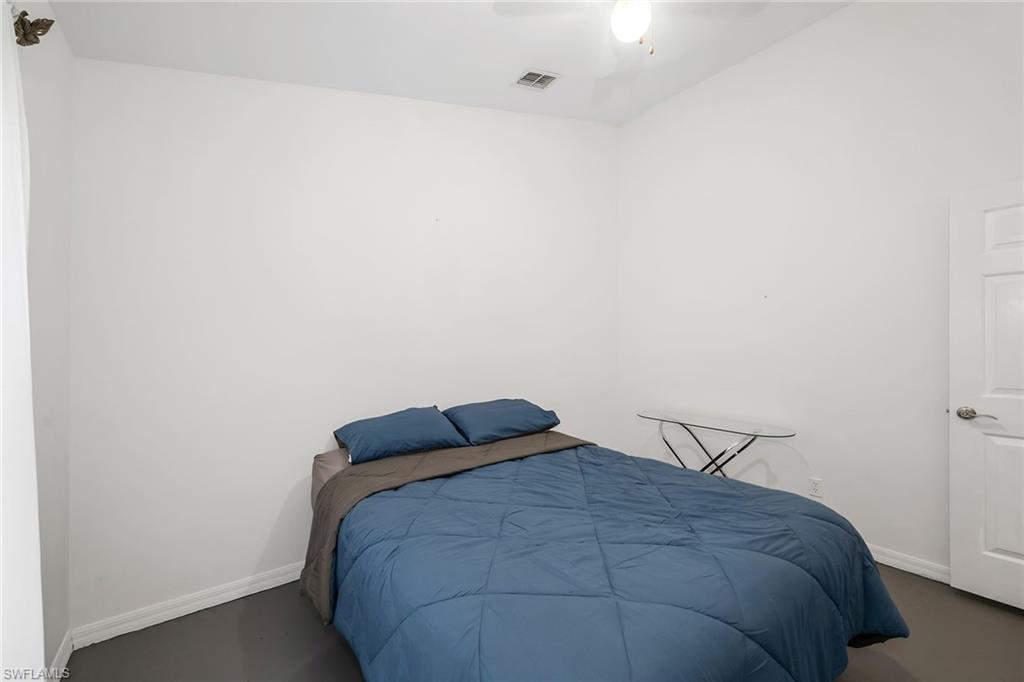 220 37th Avenue Northeast Naples, FL 34120 - Photo 29 of 49 a bedroom with a bed and a night stand