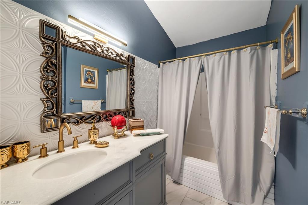 220 37th Avenue Northeast Naples, FL 34120 - Photo 30 of 49 a bathroom with a double vanity sink and a mirror