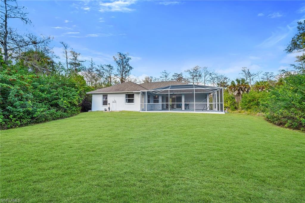 220 37th Avenue Northeast Naples, FL 34120 - Photo 44 of 49 a front view of a house with a garden