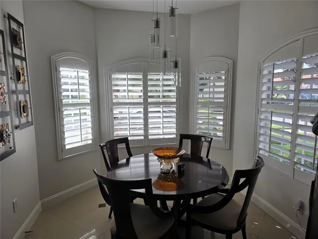 a dining room with furniture a chandelier and wooden floor