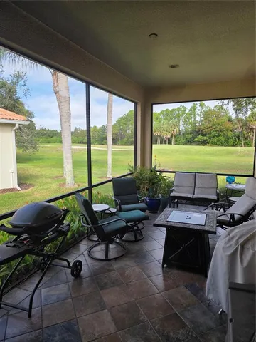a living room with patio furniture and a floor to ceiling window