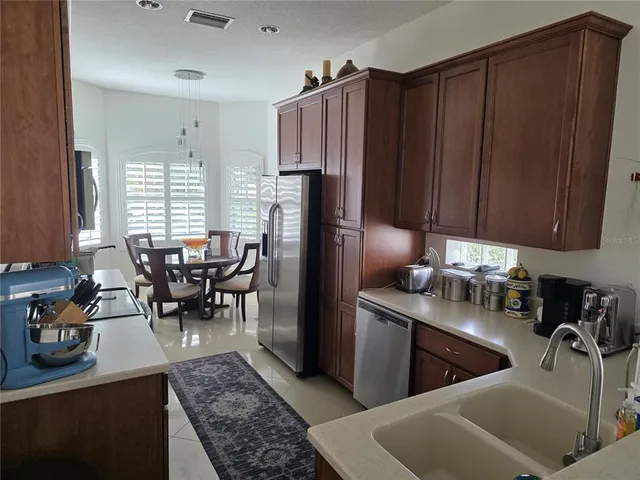a kitchen with stainless steel appliances granite countertop a refrigerator and a sink