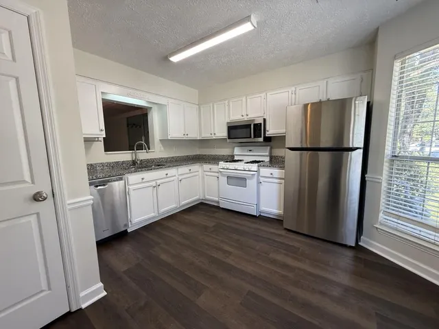 a kitchen with white cabinets and white appliances