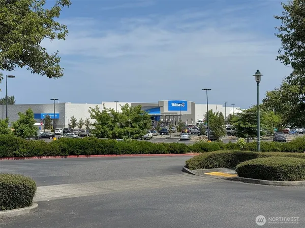 a view of a street with a cars parked and a small yard in the back