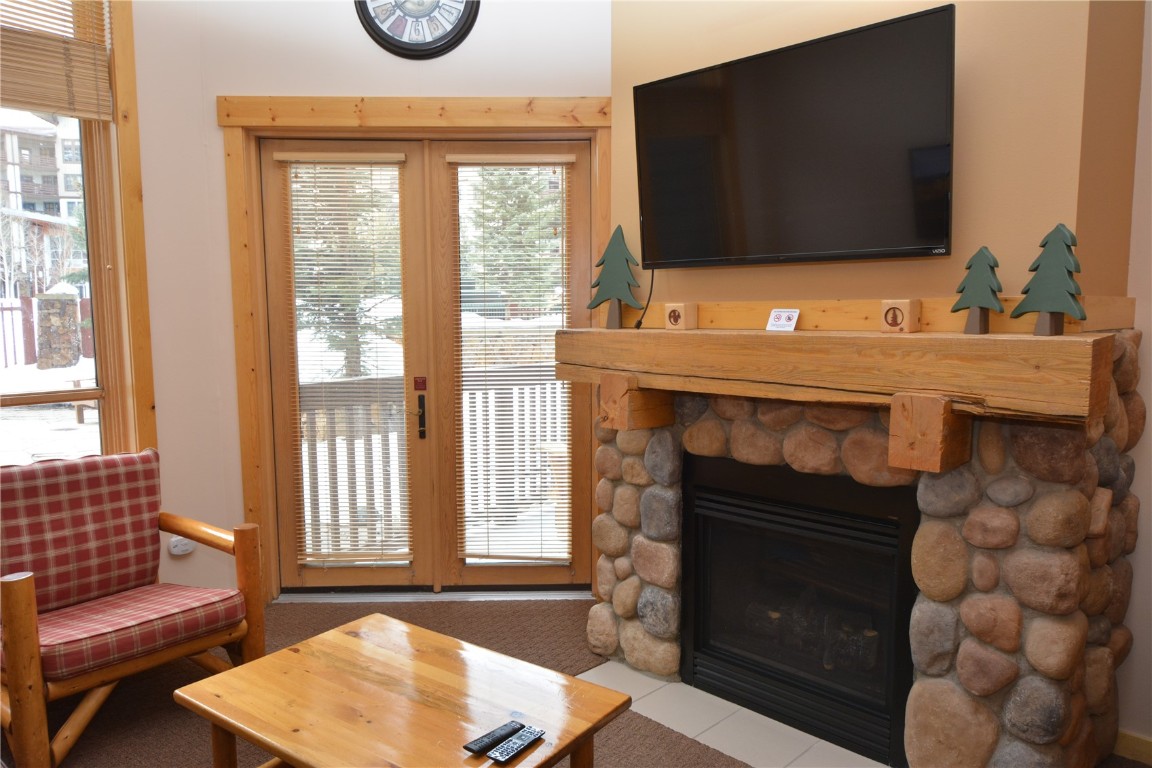 172 Copper Circle, Unit 107 Copper Mountain, CO 80443 - Photo 7 of 25 a living room with a fireplace and a flat screen tv