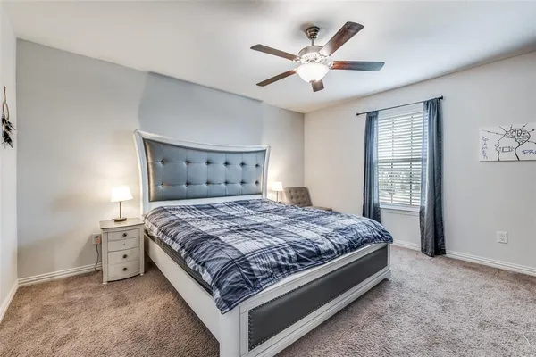 a bed sitting in a spacious bedroom next to a window