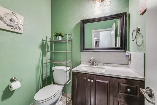 a bathroom with a toilet a sink and mirror