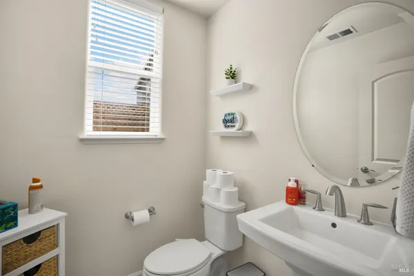 a bathroom with a sink mirror and toilet
