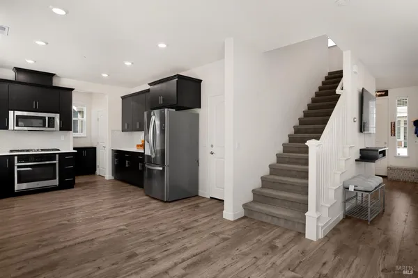 a kitchen with stainless steel appliances a refrigerator and a stove top oven