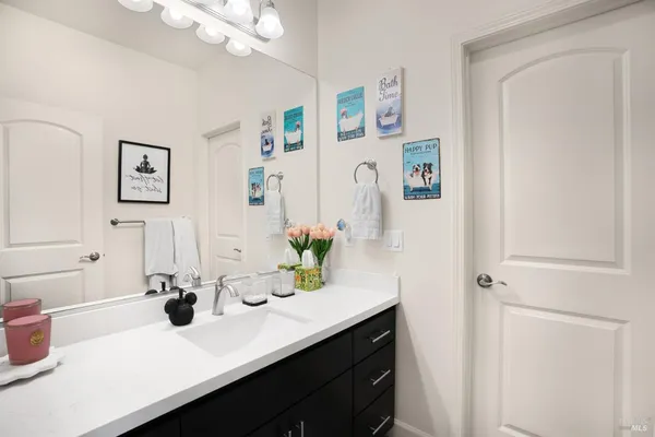a bathroom with a sink a mirror and vanity