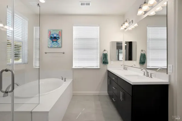 a bathroom with a tub sink and mirror