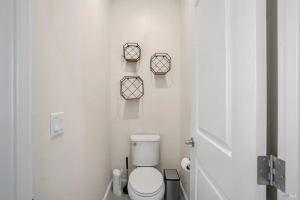 a white toilet sitting next to a white walls