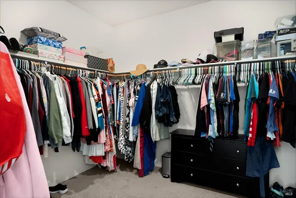 a view of walk in closet with clothes and shoes