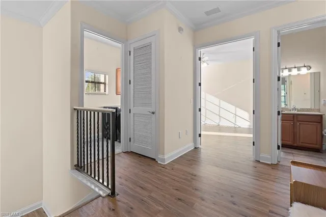 an empty room with wooden floor ceiling fan and windows