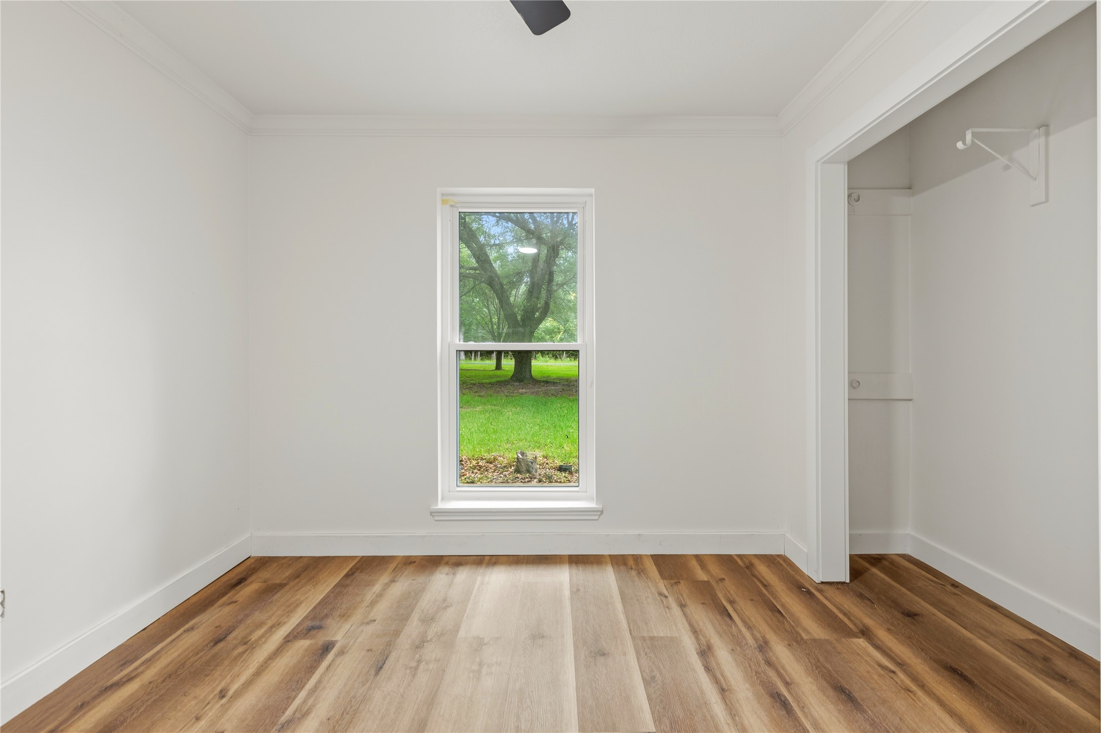 74 Robinson Road Huntsville, TX 77320 - Photo 22 of 33 a view of an empty room with a window and wooden floor